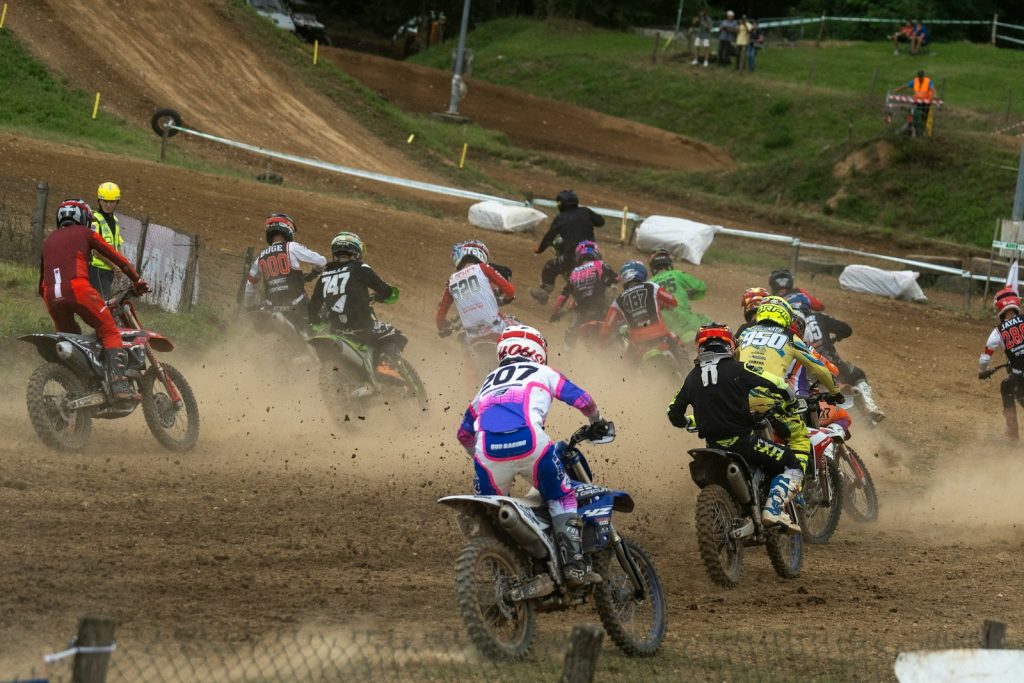 A group of people riding dirt bikes on a dirt track